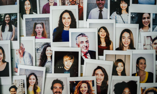 Fotos ganz verschiedener Menschen an einer Wand