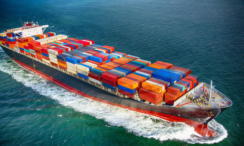 Ein mit Containern beladenes Schiff fährt über das Meer.