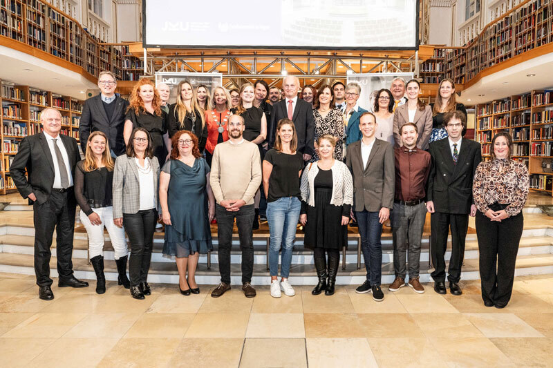 Eine Gruppe von Menschen stehen für ein Gruppenbild im Kuppelsaal zusammen