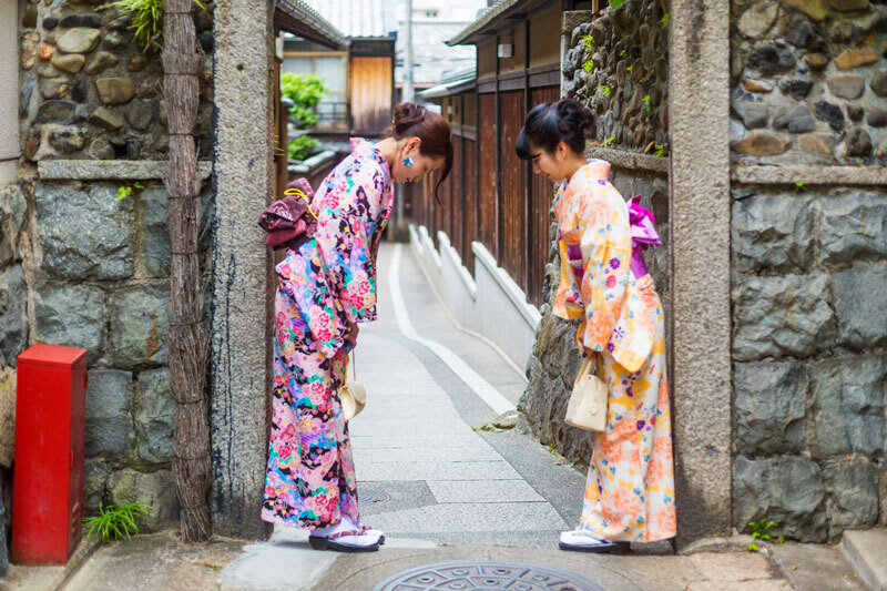 Zwei Frauen in japanischer Tracht verbeugen sich voreinander.