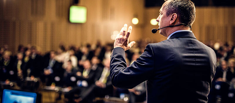 Ein Vortragende vor dem Publikum im Saal